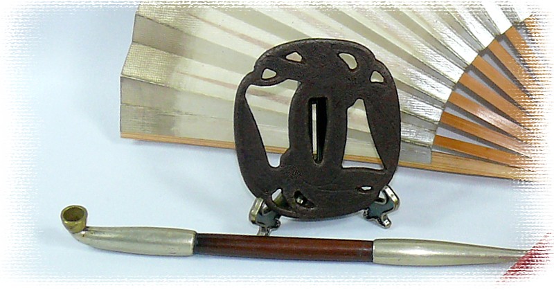 японская страинная курительная трубка и гарда (цуба) японского меча катана