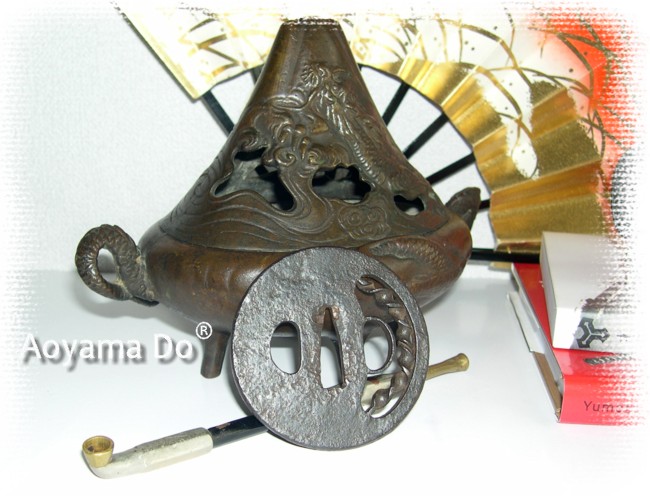 коллекция предметов японского искуссва: серебряная курительная трубка и кованная гарда меча периода Муромачи